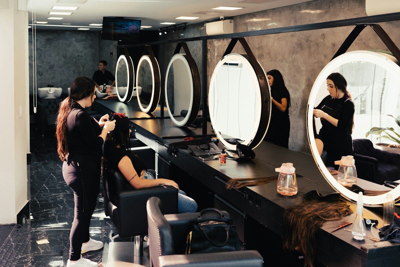Estilista atendiendo el cabello de una mujer en un salón